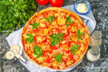 Pizza with sausage, tomatoes and cheese