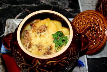 Pork with potatoes and cheese in a pot